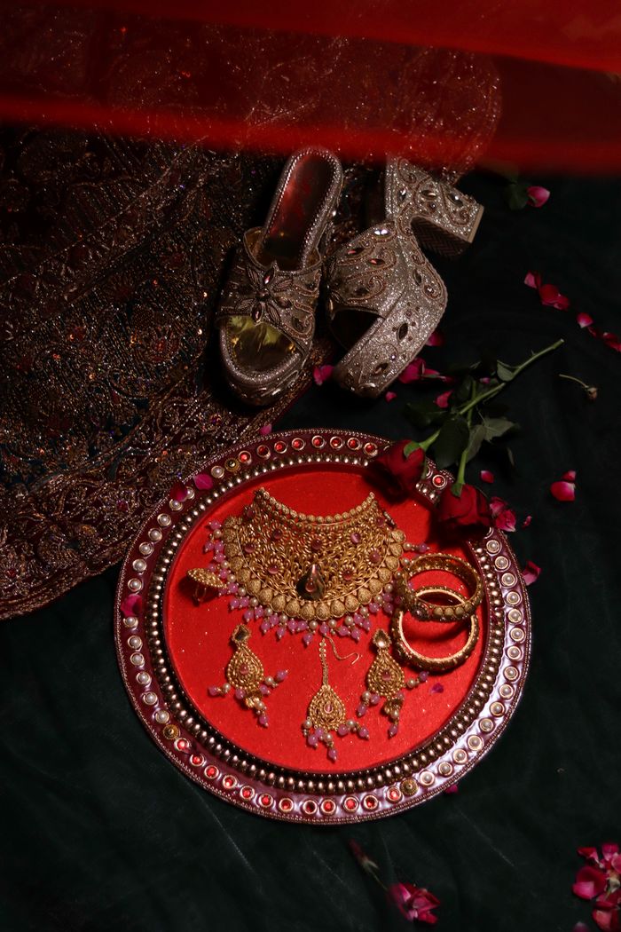 Artistic display of gold jewelry and embellished shoes, perfect for weddings.